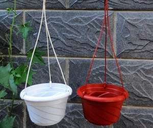 Gancho de plástico que pendura uma panela de flores na parede do quarto sem revestimento